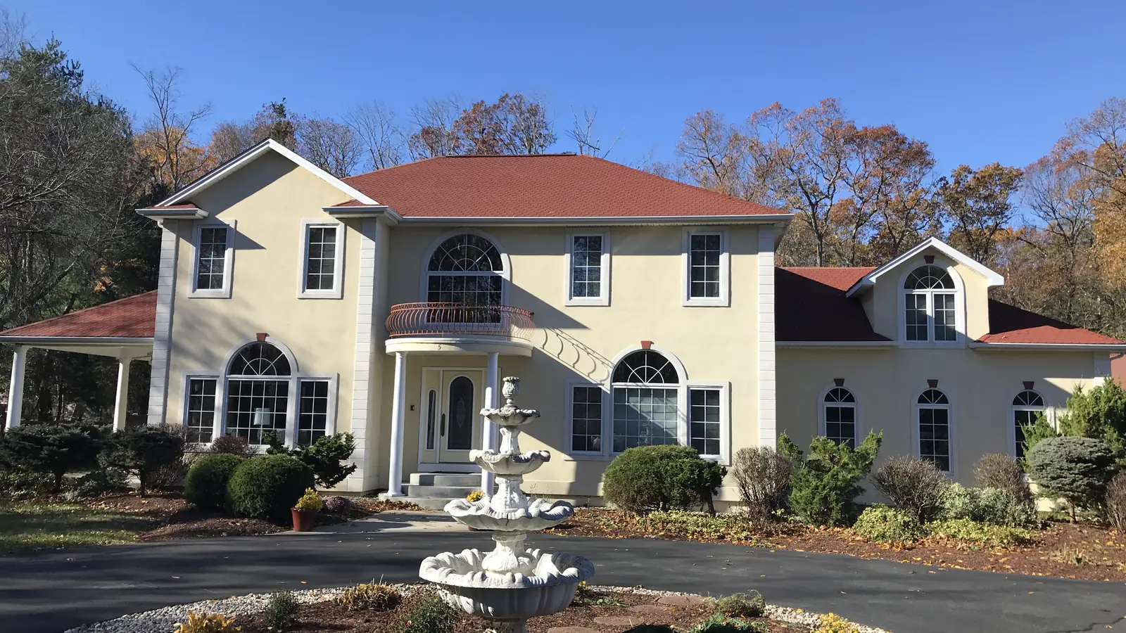 Completed red asphalt shingle roof on a large Massachusetts home