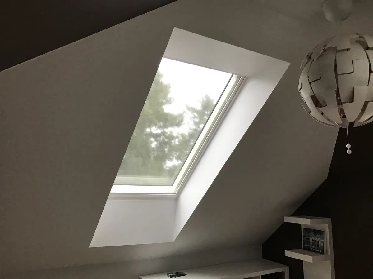 MR. ROOF. INC installer fitting a VELUX skylight into an asphalt shingle roof