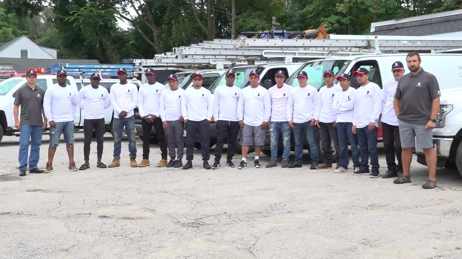 Mister Roof crew standing in front of company trucks