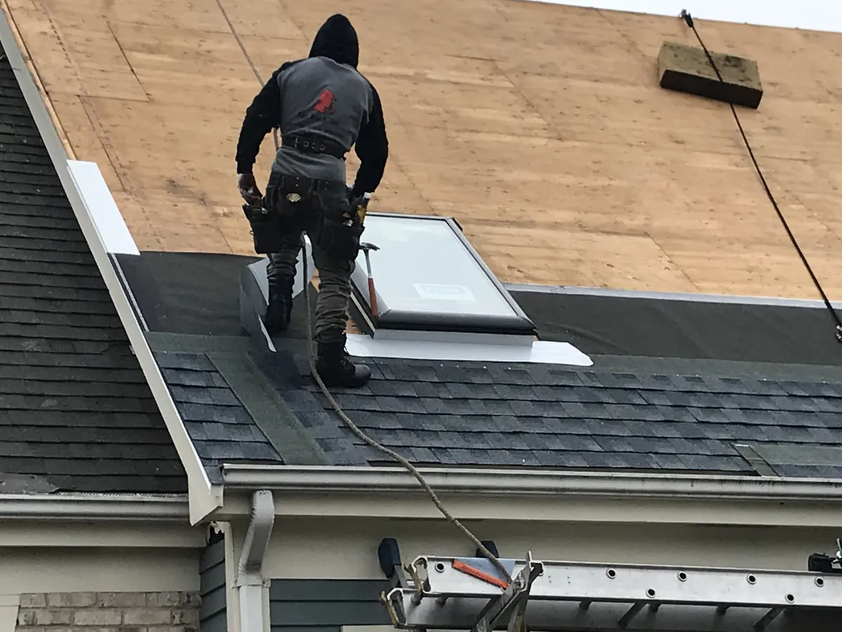 Mister Roof installer fitting a VELUX skylight into a shingle roof
