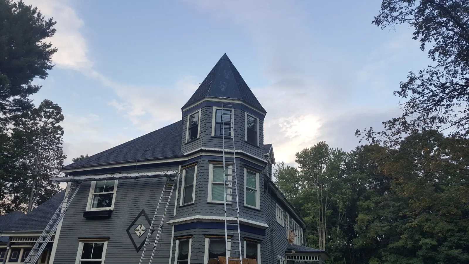 Completed asphalt shingle roof replacement on a Victorian home with a turret